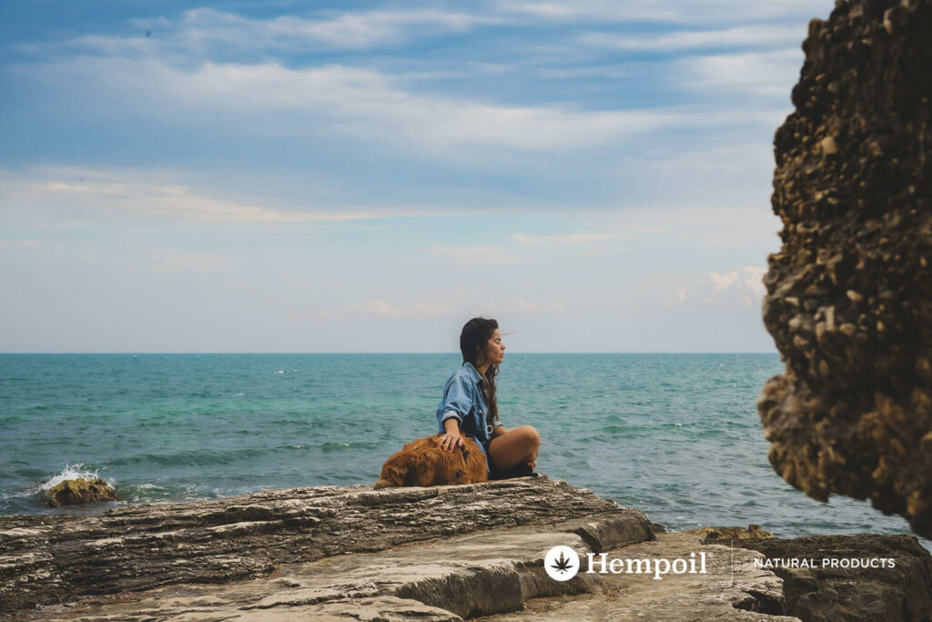 A dog and a woman relaxing by the sea during summer vacation